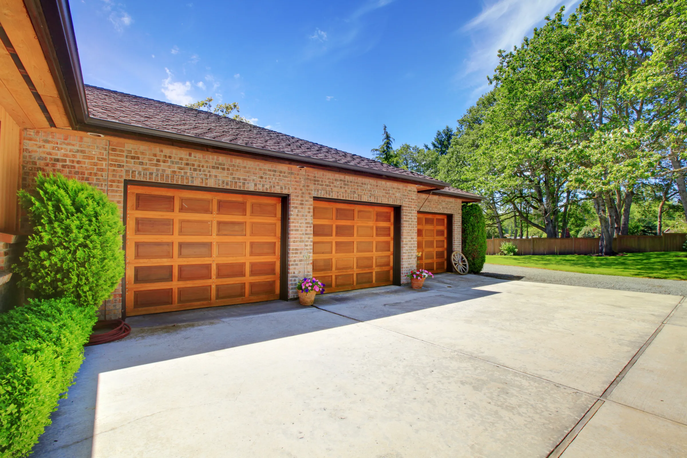Before ADU garage conversion project in Los Angeles showing existing three-car garage exterior, driveway access, brick facade, and unused garage conversion potential