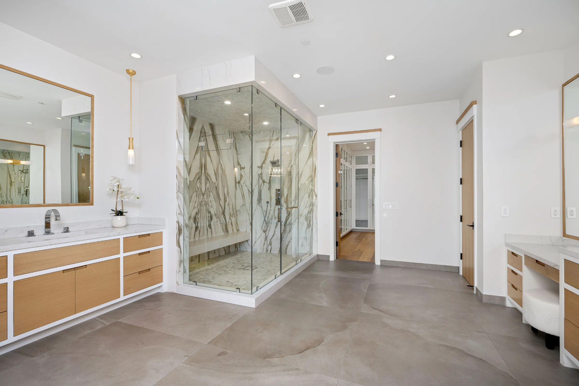 After bathroom remodeling project in Los Angeles with luxury walk-in glass shower, marble-look tile, custom vanity areas, modern lighting, updated flooring, and spa-style finishes