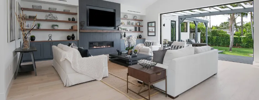 Completed Los Angeles full home remodeling project with modern living room, fireplace wall, built-in shelving, open floor plan, and indoor outdoor backyard connection